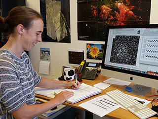 Kepler scientist at work in front of data from telescope.
