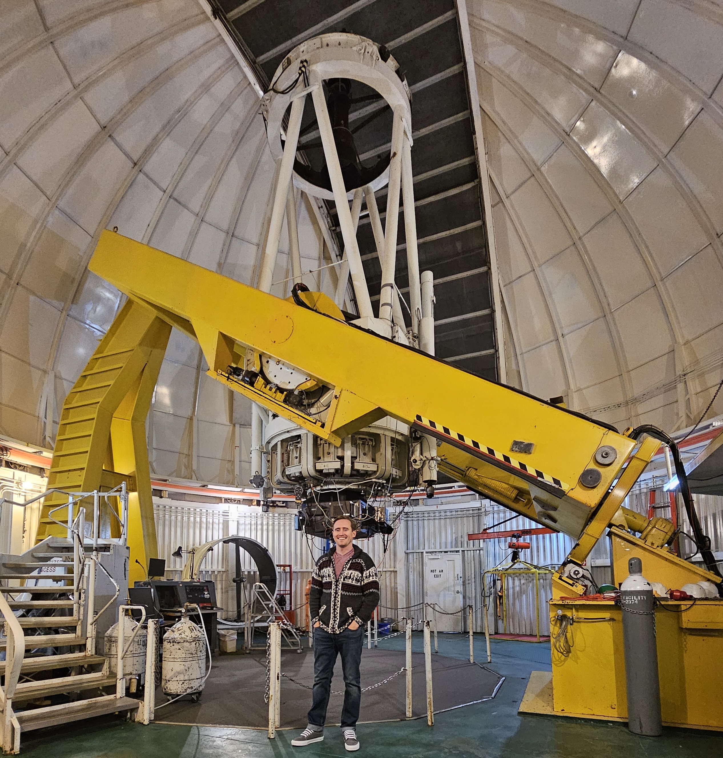 Bradley Hutson standing under an observatory telescope