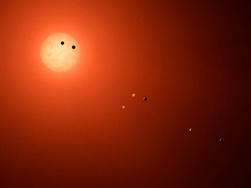 artist concept of TRAPPIST planets silhouetted by star