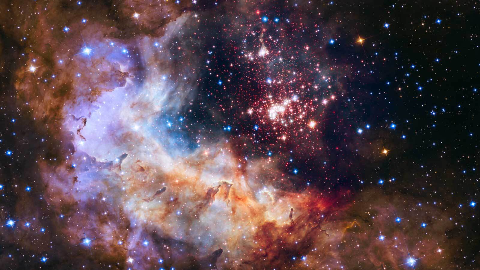 The brilliant tapestry of young stars flaring to life resembles a glittering fireworks display in this Hubble Space Telescope image. The sparkling centerpiece of this fireworks show is a giant cluster of thousands of stars called Westerlund 2. 