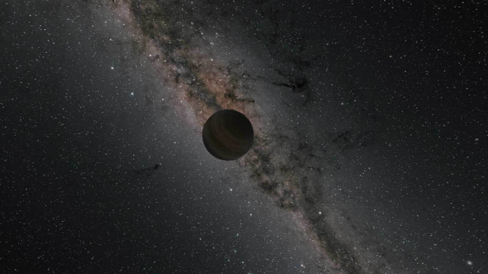 A dark planet is seen against a Milky Way backround.